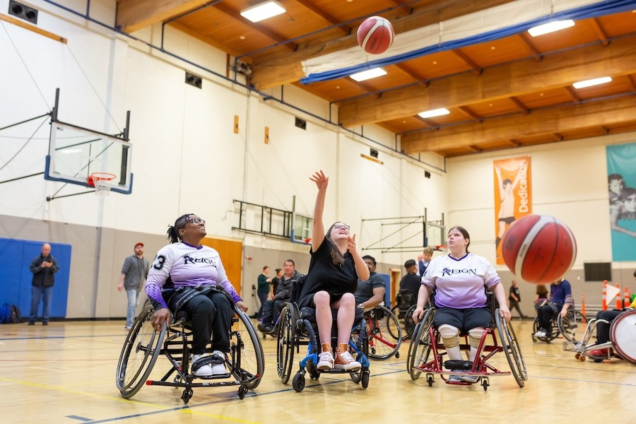 Several women in wheelchairs playing basketball.