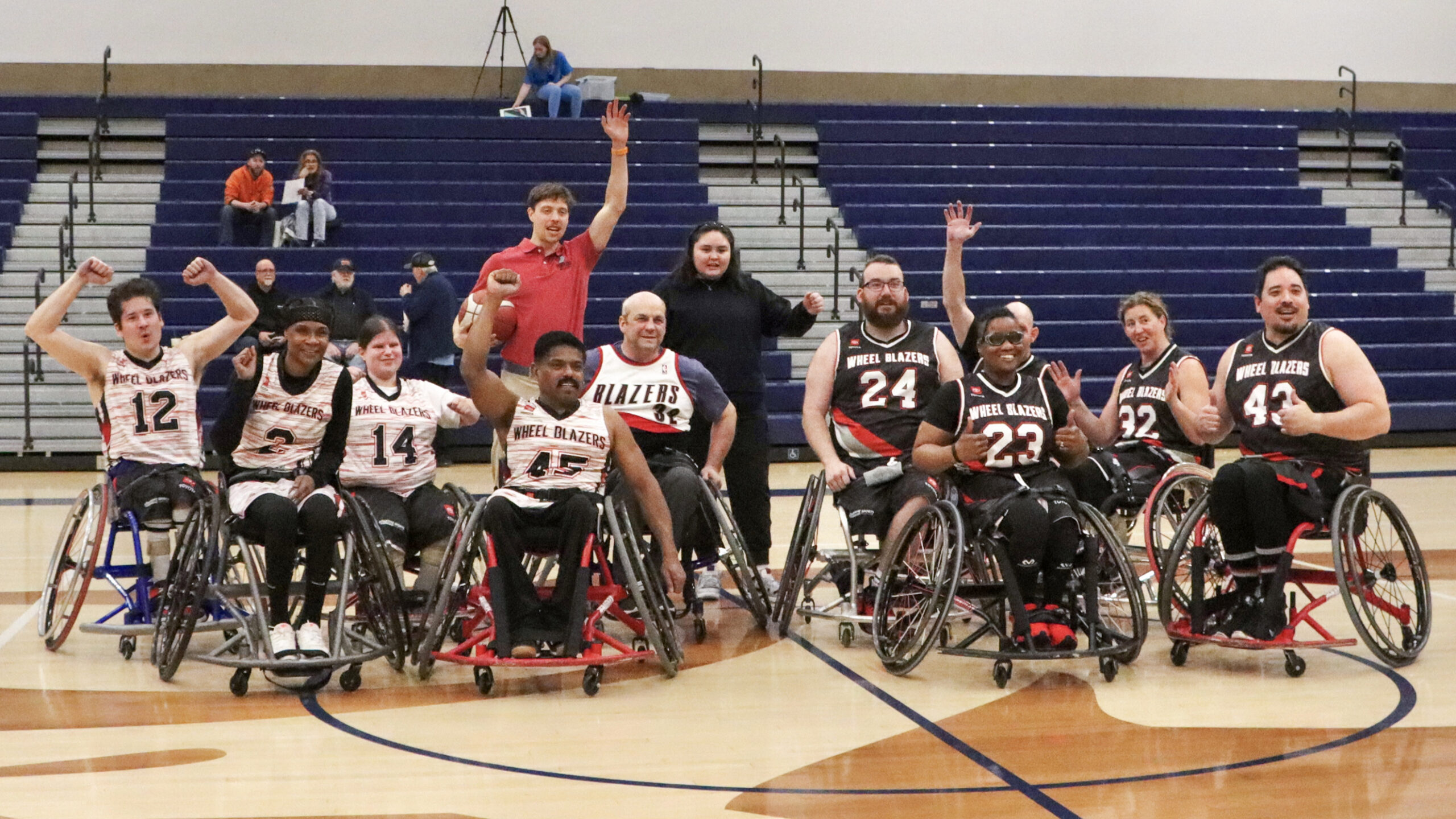 Team of smiling men and women wheelchair basketball players wearing Blazers uniforms.