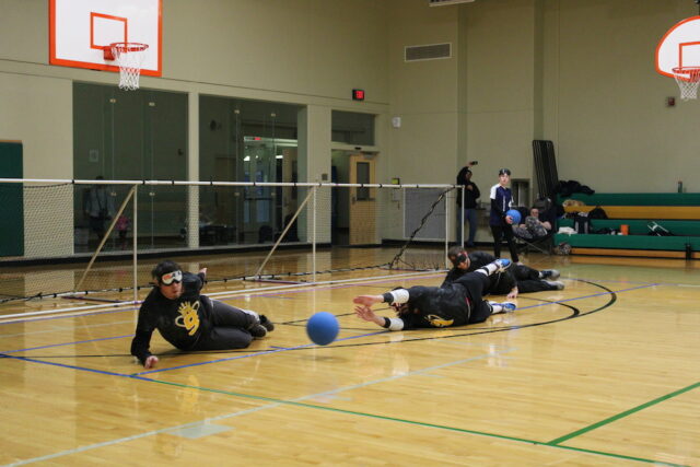 Athletes blocking the goal during a game of goalball.