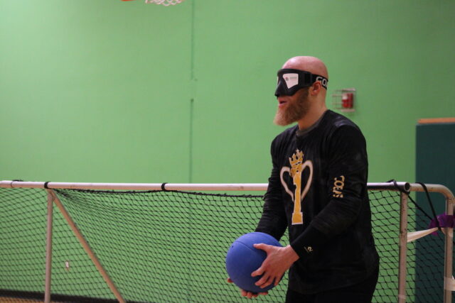 Goalball player preparing to throw the ball during an indoor game.