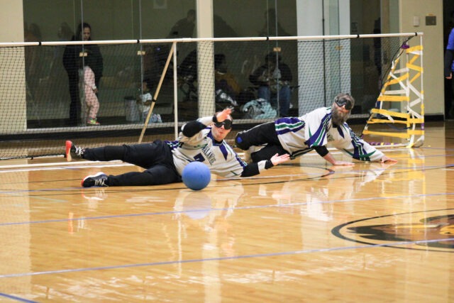 Athletes blocking the goal during a game of goalball.