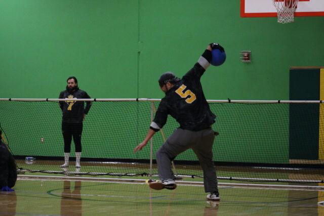 Goalball player throwing the ball during an indoor game.