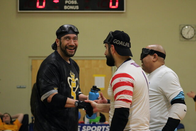 Goalball players shaking hands and smiling.