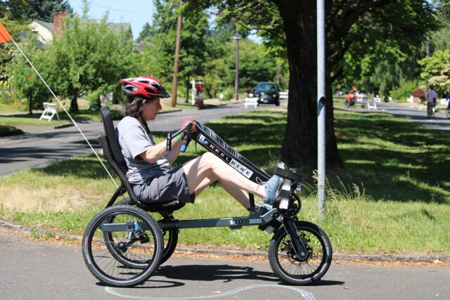 Women riding an adaptive bicycle.