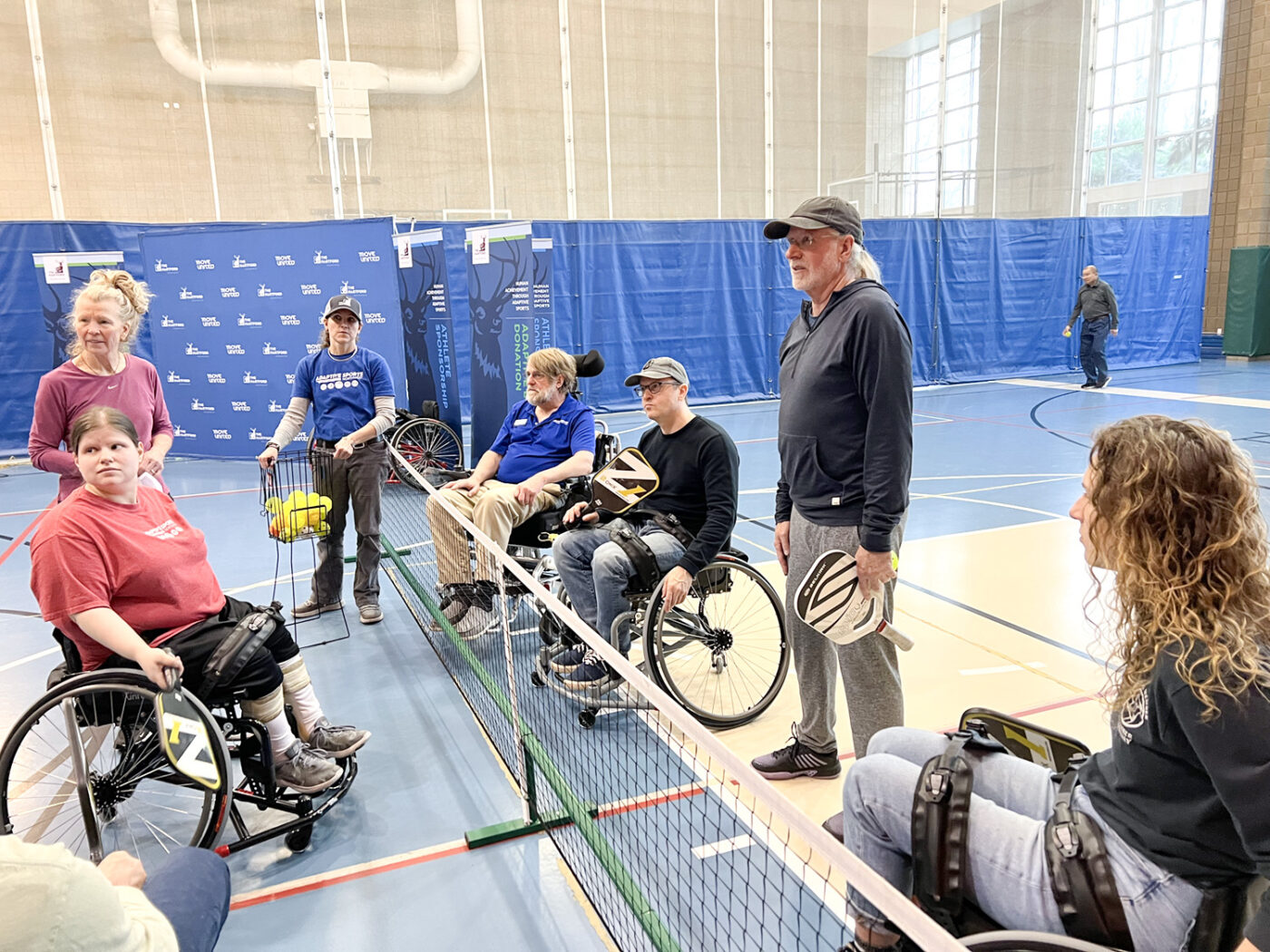 Pickleball gallery - Activation event, instructor and group at net.