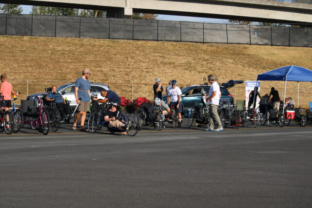 People gathered at an outdoor handcycling event.