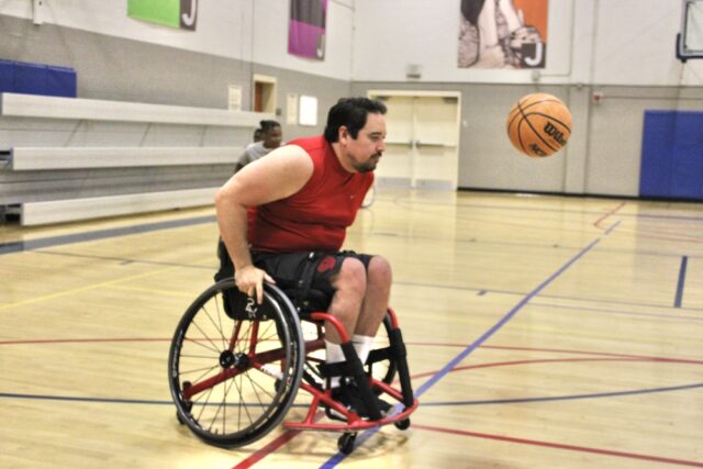 Male wheelchair basketball player going after the ball.