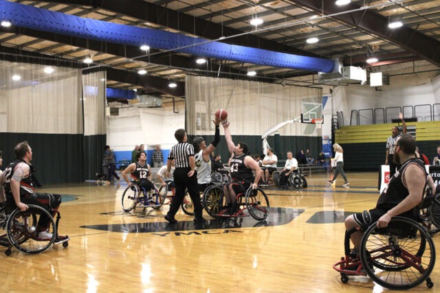 Full court view of tip-off with Blazers team and referee.