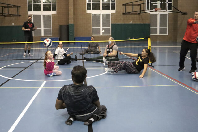 Teams of mixed ages playing sitting volleyball.