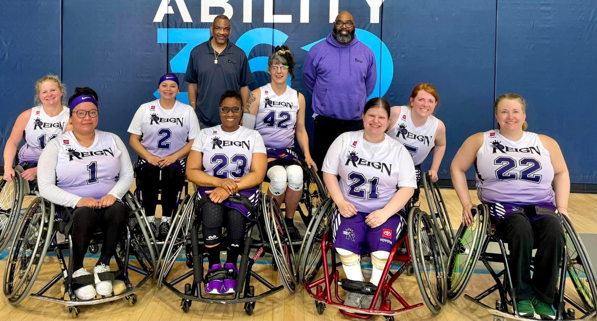 PNW Reign women's wheelchair basketball team wearing jerseys and smiles.