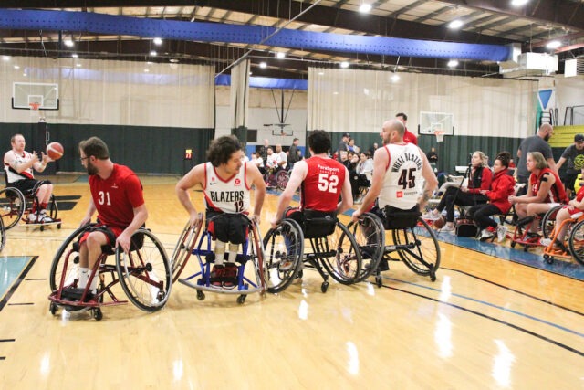 Wheelchair basketball game on an indoor court.