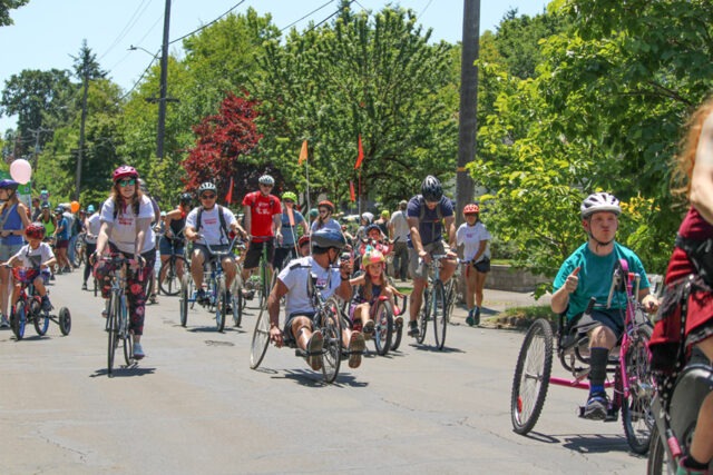 Athletes participating in a cycling road race on various types of cycles.