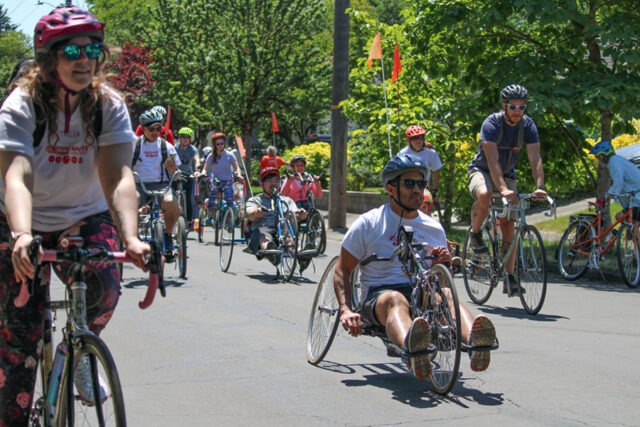 Athletes participating in a cycling road race on various types of cycles.