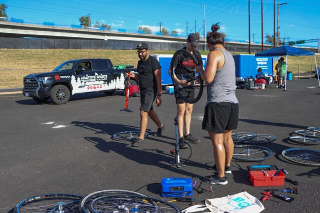 Several people assessing bicycle tires at an outdoor ASNW event.