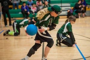 Woman throwing the ball during an indoor goalball game.