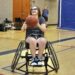 Young woman in wheelchair preparing to shoot a basketball.