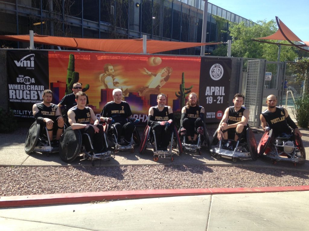 Wheelchair rugby team members posing outside.