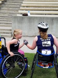 Track and field athletes in wheelchairs congratulating each other.